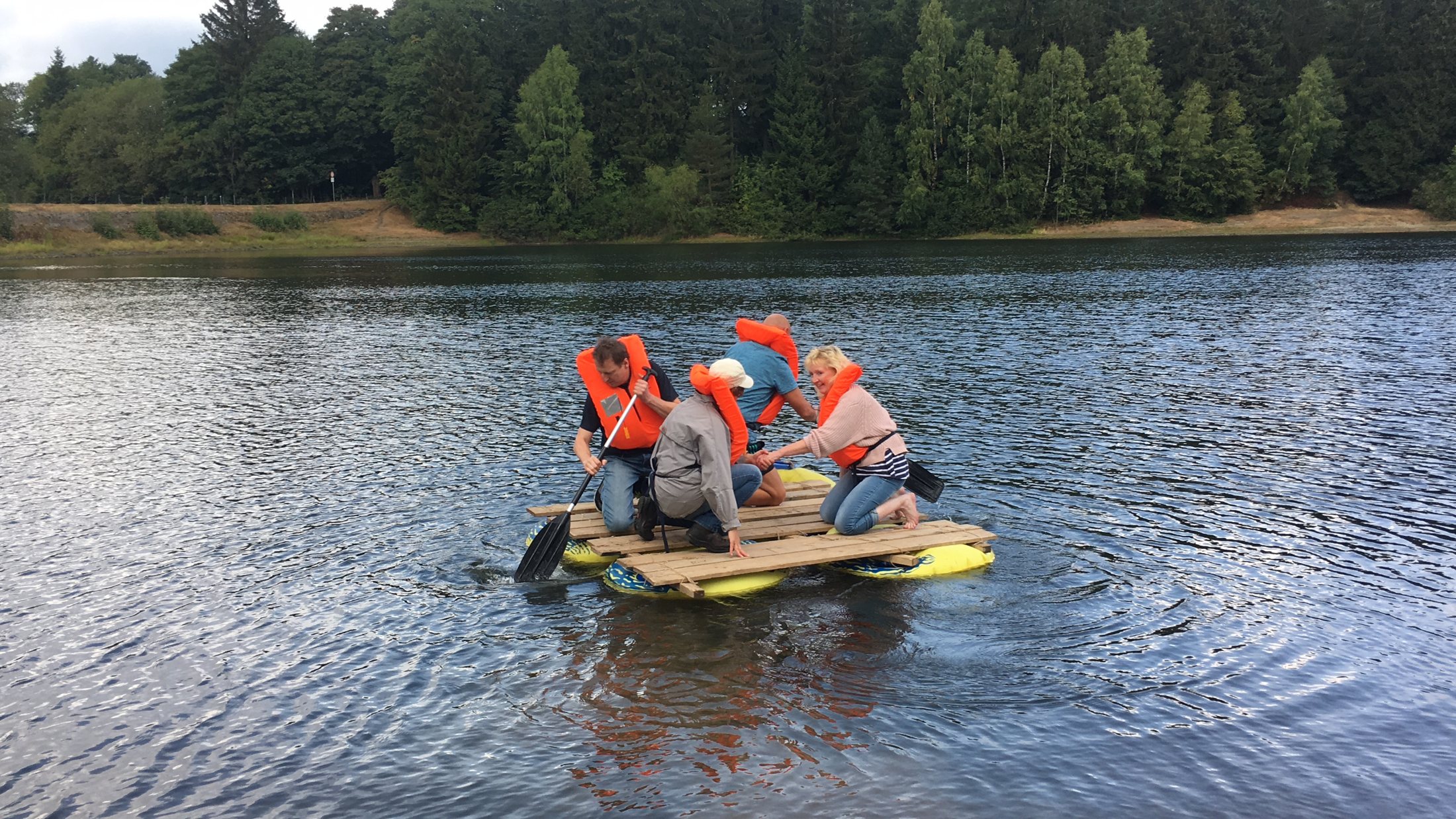 Teambuilding auf einer Harzer Talsperre — Gruppe auf einem selbstgebauten Floß