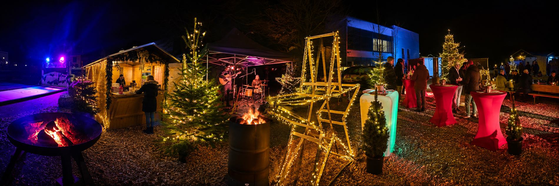 Pop-up Weihnachtsmarkt bei Nacht: Hütten, Feuertonnen, Livemusik und Stehtische auf einem Firmengelände